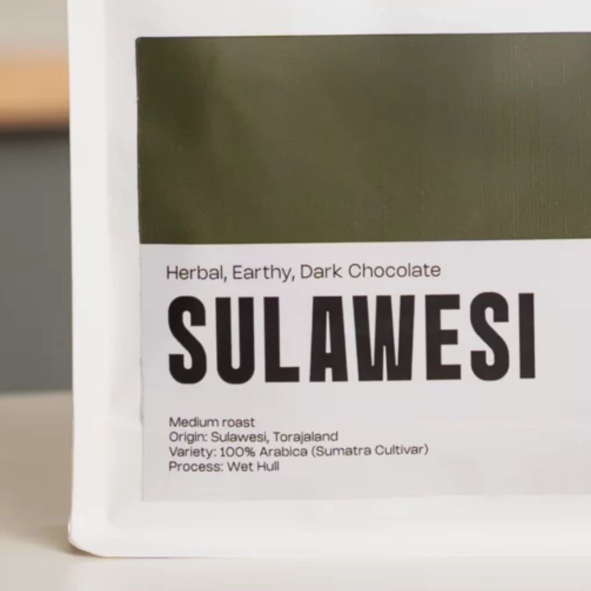 Close-up van Sulawesi Indonesië koffie met focus op het etiket en productinformatie.