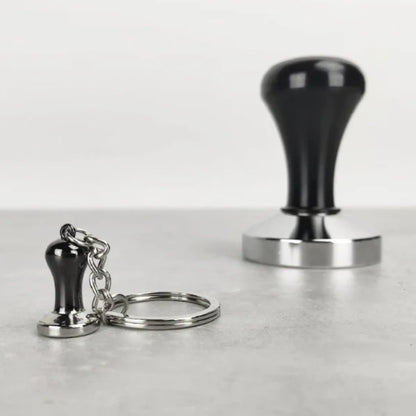 Tamper-sleutelhanger naast een grote zwarte tamper