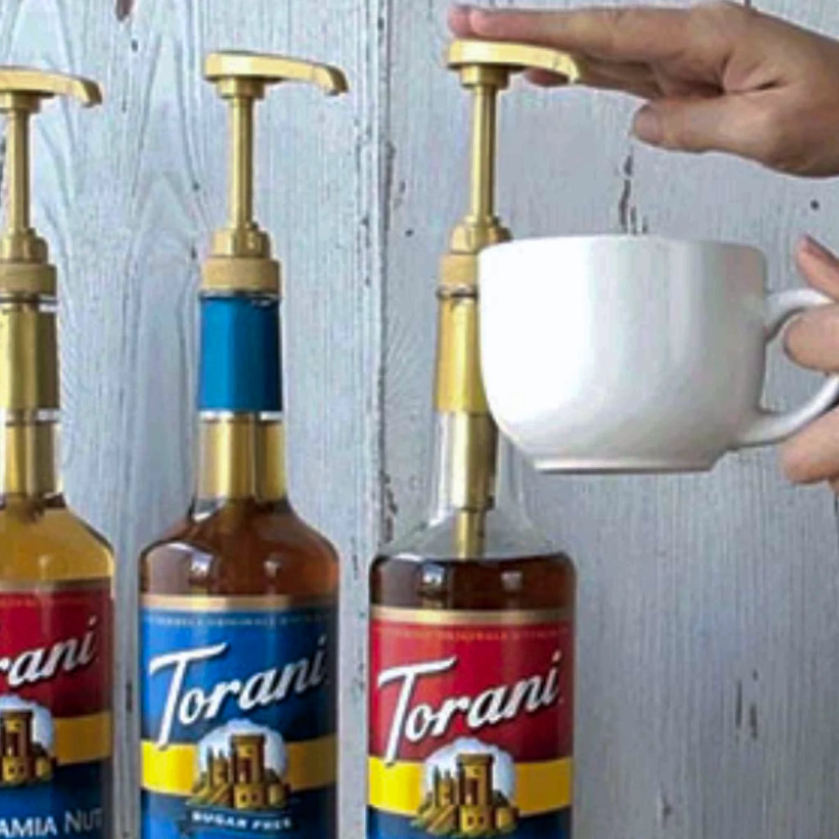 Gouden Torani sirooppomp bevestigd op een fles Caramel Siroop.