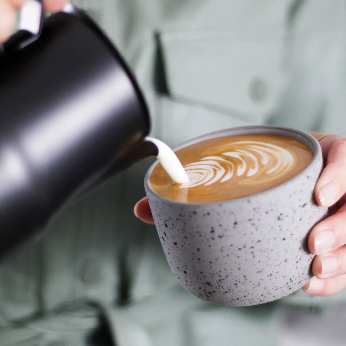 Welke melkkan kiezen? Barista giet latte art met aanbevolen zwarte melkkan
