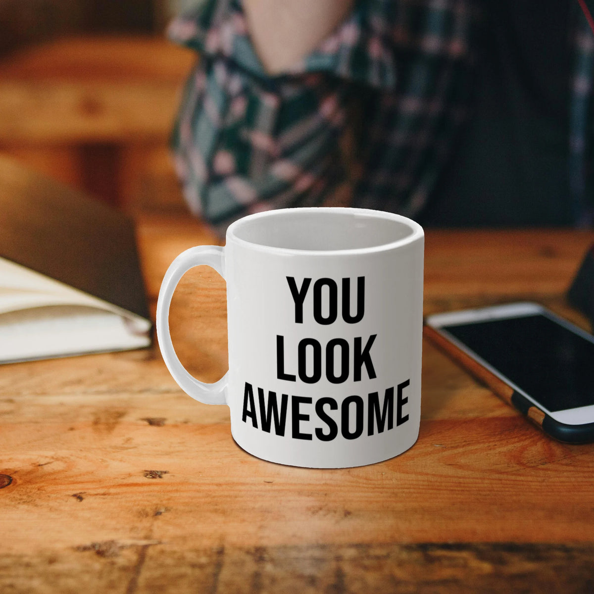 Witte mok gevuld met koffie en de tekst ‘You Look Awesome’.