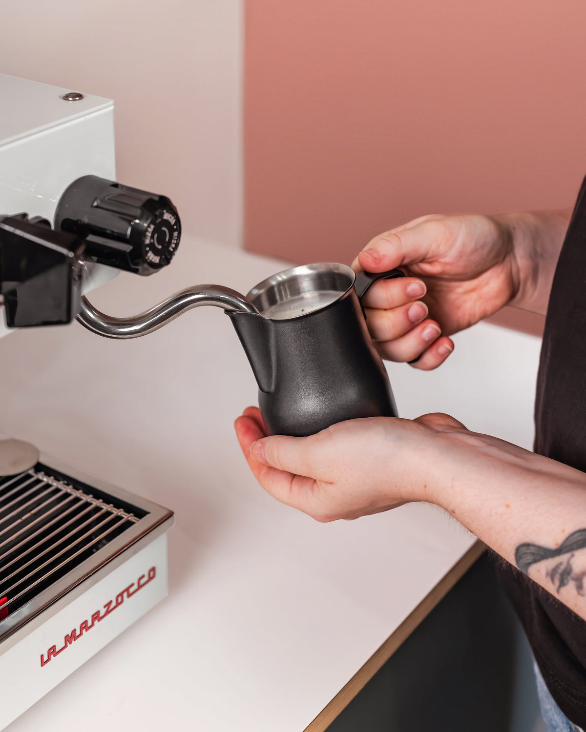 Zwarte Italiaanse melkkan 350 ml bij de stoompijp van een espressomachine