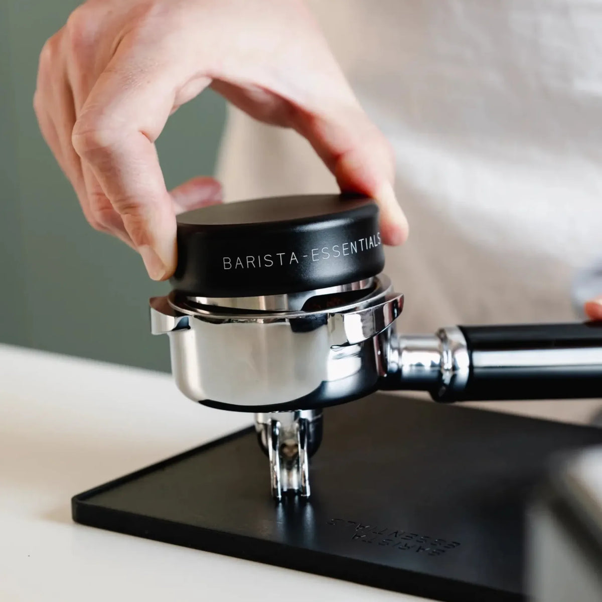 Zwarte koffieverdeler op een portafilter tijdens het verdelen